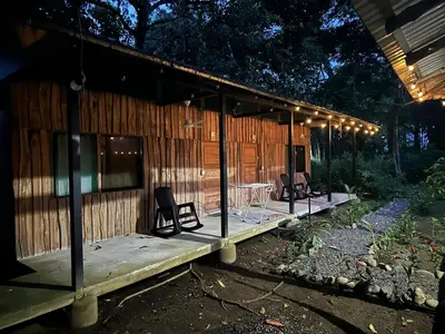 a house with chairs and a table on a porch at Almendros de Osa Lodge in Uvita