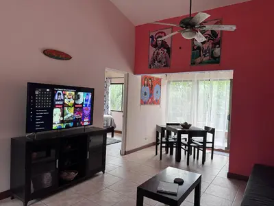 a living room with a television and a dining room at Birds of a Feather 2BR2BA Ocotal Coastal Retreat in Ocotal