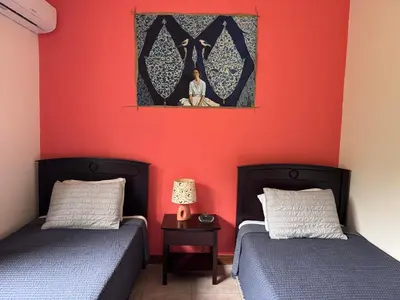 two beds in a room with red walls at Birds of a Feather 2BR2BA Ocotal Coastal Retreat in Ocotal
