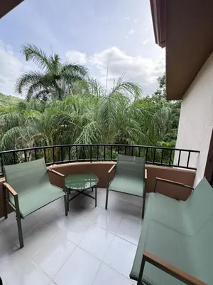 a balcony with chairs and a table and palm trees at Birds of a Feather 2BR2BA Ocotal Coastal Retreat in Ocotal