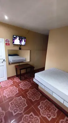 a bedroom with a bed and a tv on the wall at Hotel MANAA in Cariari