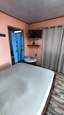 a bedroom with a large white bed and a tv at Hotel MANAA in Cariari