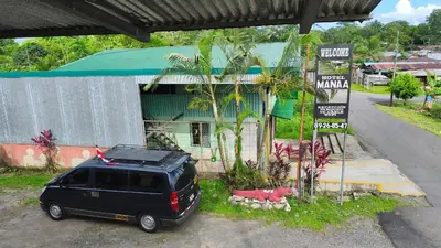 a black van parked in front of a building at Hotel MANAA in Cariari