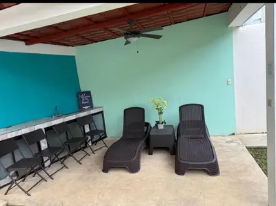 three chairs and a bar with a blue wall at Hermosa Beach in Tapantí