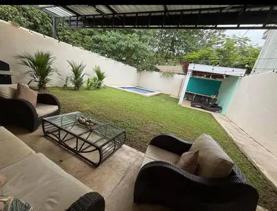 a patio with couches and a table in a yard at Hermosa Beach in Tapantí