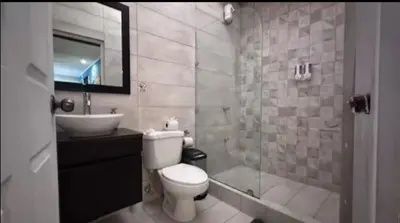 a bathroom with a toilet and a sink and a shower at Hermosa Beach in Tapantí