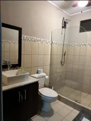 a bathroom with a toilet and a sink and a shower at Hermosa Beach in Tapantí