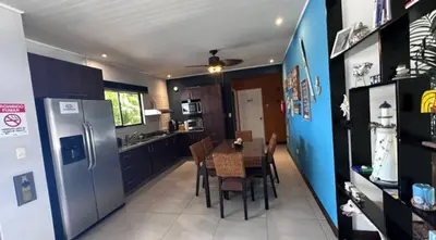 a kitchen with a table and a refrigerator at Hermosa Beach in Tapantí