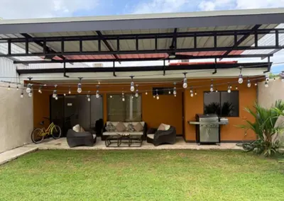 a covered patio with couches and a grill at Hermosa Beach in Tapantí