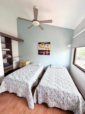 two beds in a bedroom with a ceiling fan at Gorgeous Three Bedroom Townhouse in Coco
