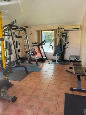 a gym with several treadmills and exercise machines at Gorgeous Three Bedroom Townhouse in Coco