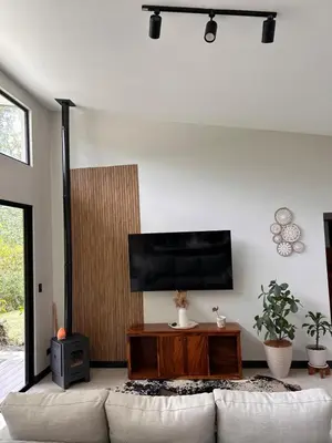 a living room with a couch and a flat screen tv at Los Guayabos in Sarchí
