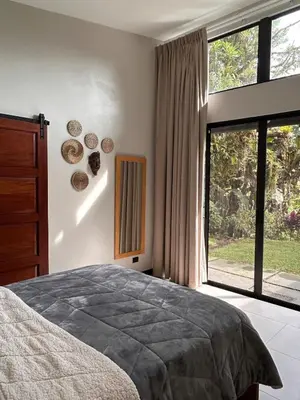 a bedroom with a bed and a large window at Los Guayabos in Sarchí