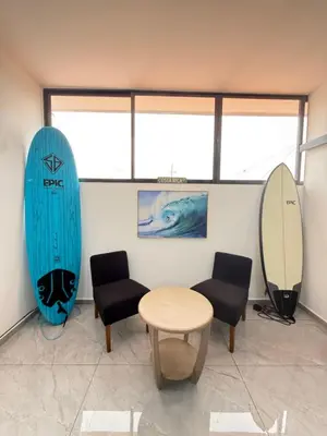 a room with two surfboards and a table and chairs at Casa Azul Jaco in Jacó