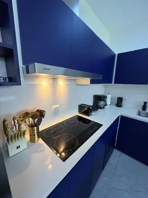 a kitchen with blue cabinets and a stove top oven at Casa Azul Jaco in Jacó