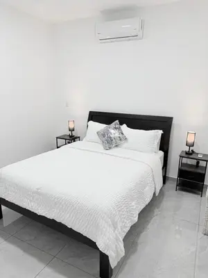 a bedroom with a large white bed with two night stands at Casa Azul Jaco in Jacó