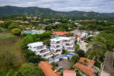 an aerial view of a building in a city at Modern Top-Floor Condo with Panoramic Views and Community Pool in Coco