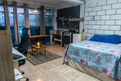 a bedroom with a bed and a kitchen with a stove at 31 Studio Apartment in Heredia