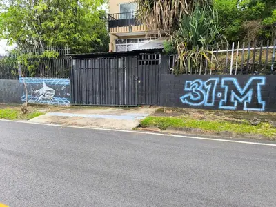 a fence with graffiti on the side of a street at 31 Studio Apartment in Heredia