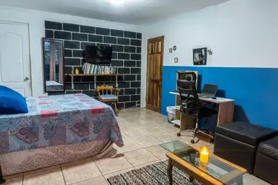 a bedroom with a bed and a desk in a room at 31 Studio Apartment in Heredia