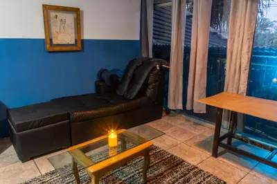 a living room with a leather couch and a table at 31 Studio Apartment in Heredia