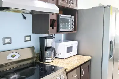 a kitchen with a coffee maker and a microwave at Southern Escapes Apartment in Quepos