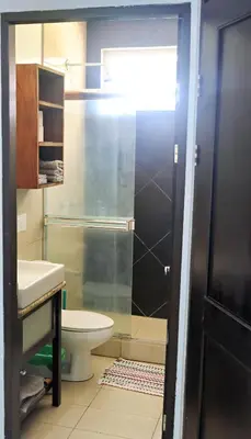 a bathroom with a toilet and a sink and a shower at Southern Escapes Apartment in Quepos
