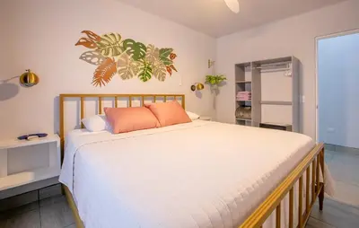 a bedroom with a bed with white sheets and orange pillows at Villa María - Perfect Getaway in Fortuna