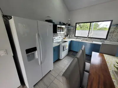 a kitchen with blue cabinets and a white refrigerator at Villa María - Perfect Getaway in Fortuna