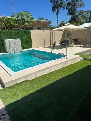 a swimming pool in a yard next to a lawn at The Toucan's House