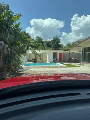 a car parked in front of a house with a swimming pool at The Toucan's House