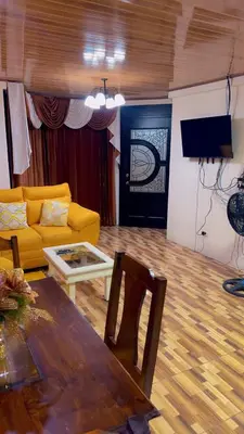 a living room with a yellow couch and a table at The Toucan's House