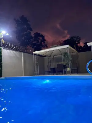 a swimming pool at night with a white canopy at The Toucan's House