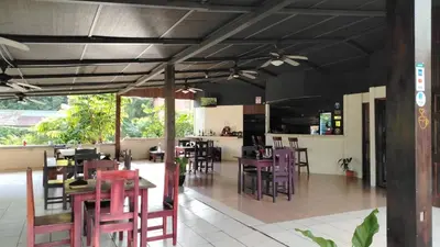 a restaurant with tables and chairs in a room at Cabinas Hidalgo in Ojochal