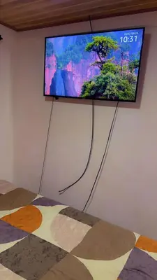 a flat screen tv on a wall in a bedroom at La Casa del Tucán in Puerto Limón