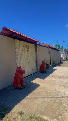 two red dragon statues sitting next to a building at La Casa del Tucán in Puerto Limón