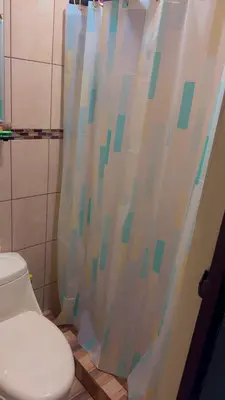 a bathroom with a toilet and a shower curtain at La Casa del Tucán in Puerto Limón