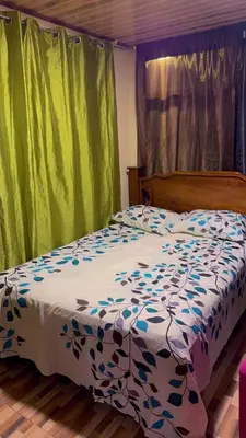 a bedroom with a bed with a blue and white comforter at La Casa del Tucán in Puerto Limón