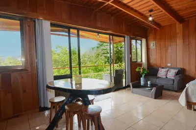 a living room with a table and chairs and a couch at Las Marias Monteverde - Mountain View Cottages & Gardens in Monteverde Costa Rica