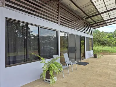a patio with two chairs and large windows at Finca Chavela in Buenos Aires