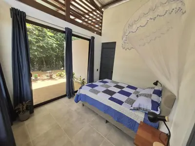 a bedroom with a bed and a large window at Finca Chavela in Buenos Aires