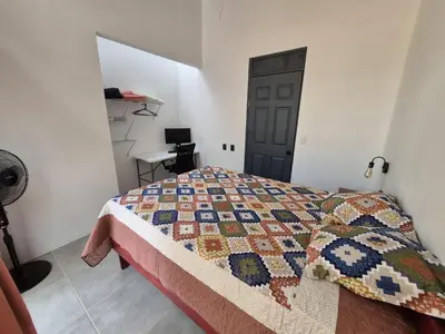a bedroom with a bed with a quilt on it at Finca Chavela in Buenos Aires
