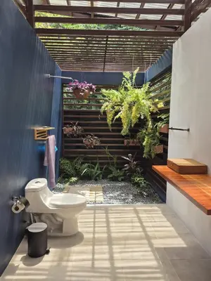 a bathroom with a toilet and plants on the wall at Finca Chavela in Buenos Aires