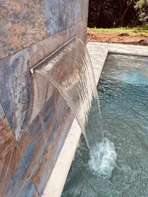 a water fountain on the side of a pool of water at Finca Chavela in Buenos Aires