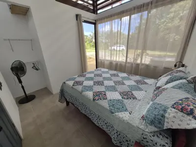 a bedroom with a quilt on a bed and a window at Finca Chavela in Buenos Aires