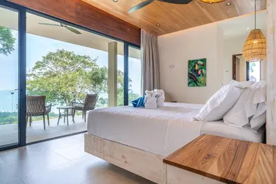 a bedroom with a bed and a large window at Casa LaVista - by Pura Villas in Uvita