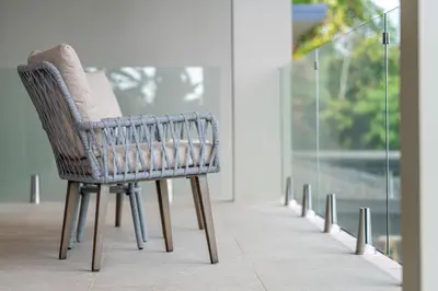 a wicker chair sitting in a room with a window at Casa LaVista - by Pura Villas in Uvita