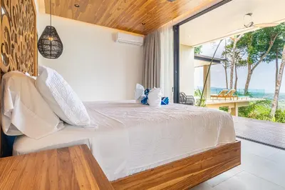 a bedroom with a large white bed and a balcony at Casa LaVista - by Pura Villas in Uvita