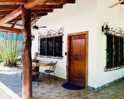a room with a table and a wooden door at Tres Corazones in Carrillo