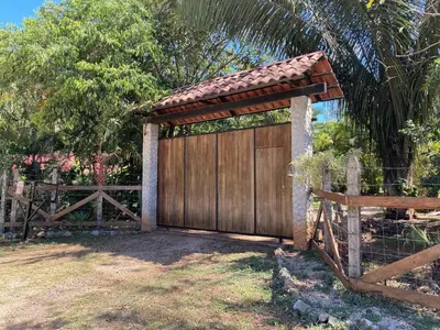 a wooden garage with a gate and a fence at Tres Corazones in Carrillo